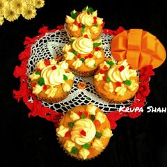 A picture of Mango cupcakes with tutti frutti.