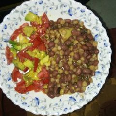 A picture of Githeri garnished with tomatoes and avocado.