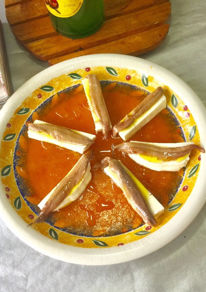 Una foto de Anchoas y queso fresco con gelatina de tomate