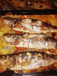 Una foto de Lubina al horno con patatas a lo pobre