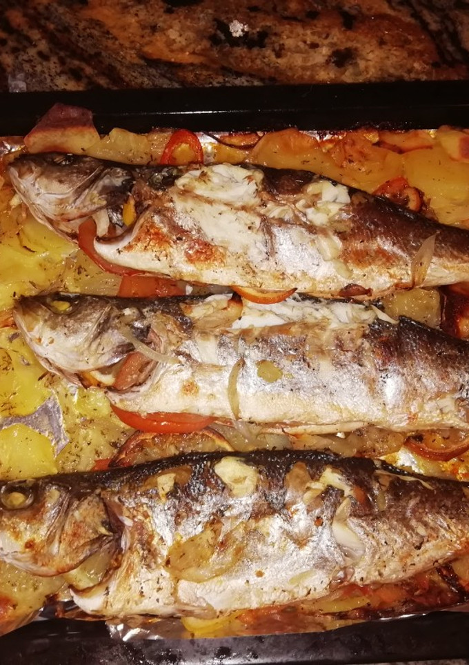 Una foto de Lubina al horno con patatas a lo pobre