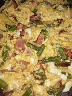 Una foto de Huevos revueltos con espárragos trigueros, bacon y queso