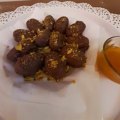 A picture of تمر محشي مكسّرات مغطى بالشوكولاتة.