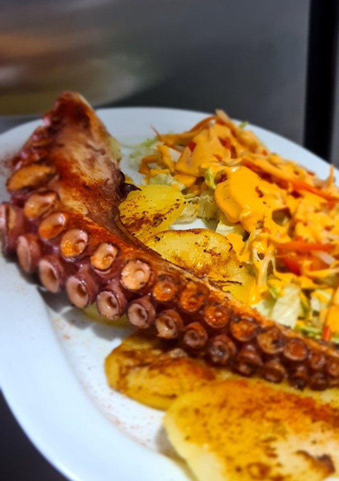 Una foto de Pulpo a la plancha con patatas panaderas y ensalada