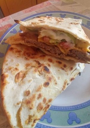 A picture of Piada-Burger with Cheddar, Lettuce, Tomatoes, and Yogurt Sauce.