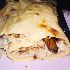 A picture of Fried egg and plantain wraped in pita bread.