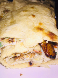 A picture of Fried egg and plantain wraped in pita bread.