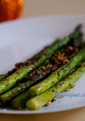 A picture of Burnt garlic aspagauraus topped with parmesan cheese.