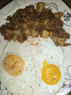 A picture of Aaloo Qeema with fried Eggs.