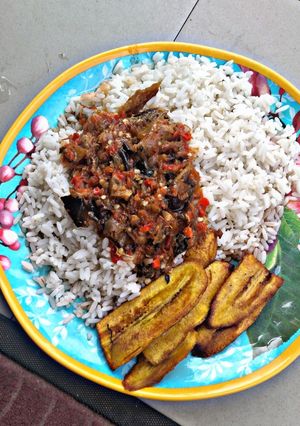 A picture of Rice and stew with fried plantain.