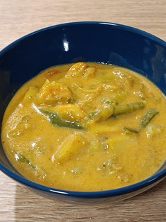Una foto de Encocada de sepia y langostinos al curry rojo
