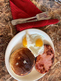 Una foto de Tortitas, jamón, y huevos con el sol arriba