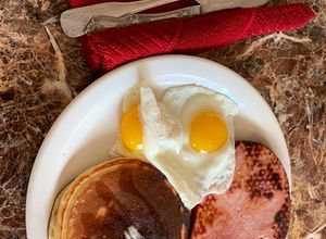 Una foto de Tortitas, jamón, y huevos con el sol arriba