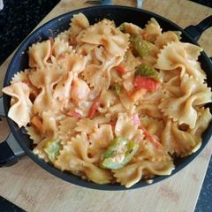 A picture of Farfalle pasta in veggies and cream.