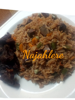 A picture of Brown fried rice with fried meat.