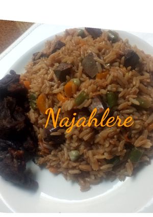 A picture of Brown fried rice with fried meat.