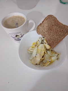 Una foto de Desayuno con huevos revuelto y rebanada de pan