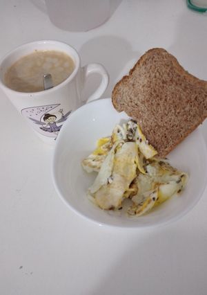 Una foto de Desayuno con huevos revuelto y rebanada de pan