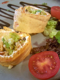 Una foto de Enrollado (Brazo de Gitano) de escalivada con relleno tropical, queso crema y mermelada de pimientos
