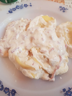 Una foto de Raviolis rellenos de queso de cabra y cebolla en salsa de jamón