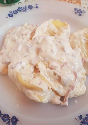 Una foto de Raviolis rellenos de queso de cabra y cebolla en salsa de jamón