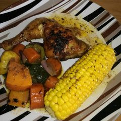 A picture of Grilled chicken with sweet corn and roast veggies.