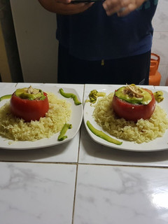 Una foto de Tomate 🍅 relleno con pollo🍗 y palta con una cama de arroz