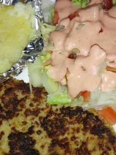Una foto de Milanesa de res, papas horneadas con queso mozarela y ensalada