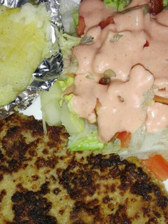 Una foto de Milanesa de res, papas horneadas con queso mozarela y ensalada