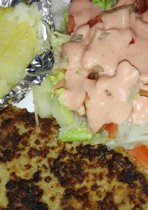 Una foto de Milanesa de res, papas horneadas con queso mozarela y ensalada