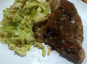 Una foto de Pollo en dos fondos de cocción con ensalada de repollo y cebolla