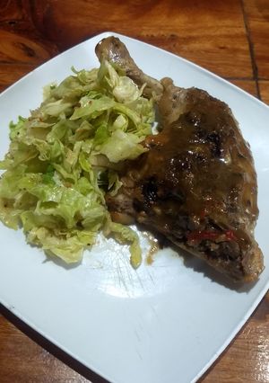 Una foto de Pollo en dos fondos de cocción con ensalada de repollo y cebolla