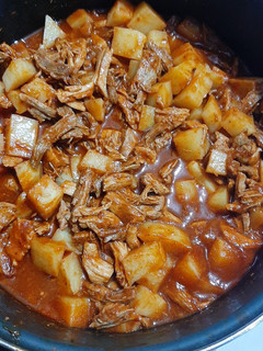Una foto de Pierna de cerdo con papitas y chile rojo