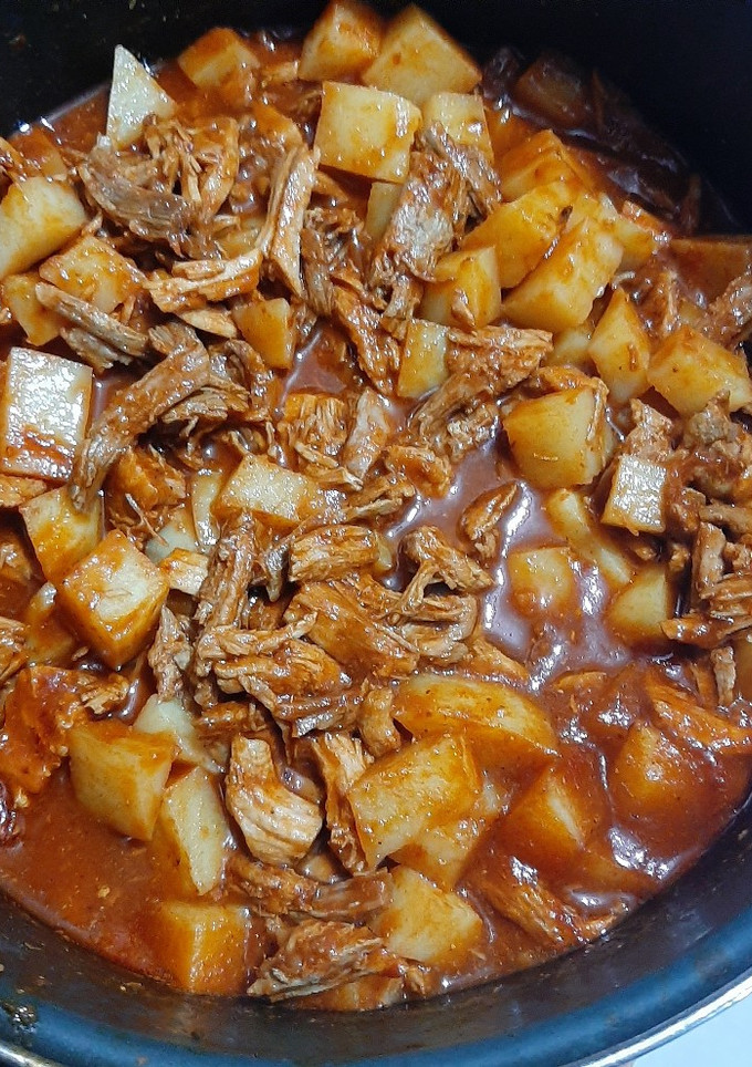 Una foto de Pierna de cerdo con papitas y chile rojo