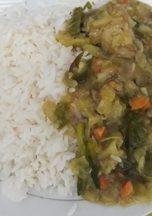A picture of White rice with chicken sauce.