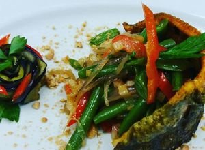 Una foto de Filete de trucha en costra de almendras y verduras salteadas