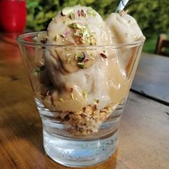 A picture of Banana ice cream with granola and peanut butter sauce.