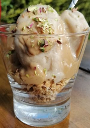 A picture of Banana ice cream with granola and peanut butter sauce.