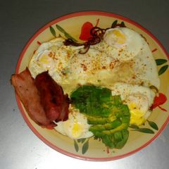 A picture of Fried eggs with fried beef and avacado.