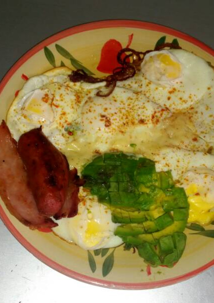 A picture of Fried eggs with fried beef and avacado.