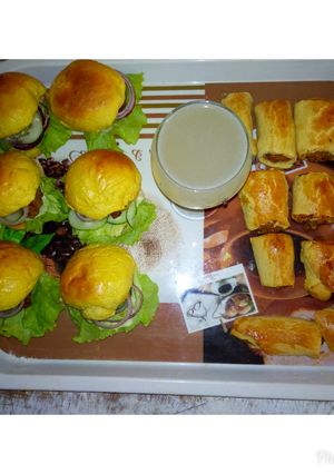 A picture of Pineapple juice with sausage Roll.