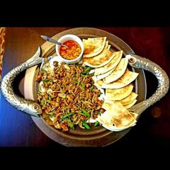 A picture of Steak and eggs with pita.