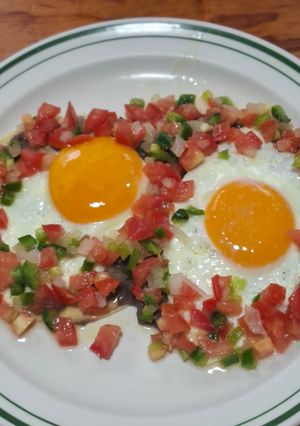 Una foto de Huevos fritos con frijoles y salsa bandera