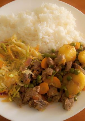 A picture of White rice with beaf stew & steamed cabbage.