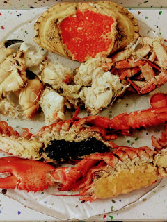 Una foto de Bogavante con caviar y perlas de fruta de la pasión y buey de mar relleno con perlas de salmón