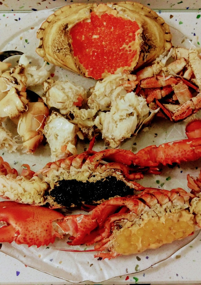 Una foto de Bogavante con caviar y perlas de fruta de la pasión y buey de mar relleno con perlas de salmón