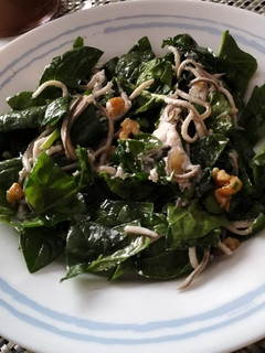 Una foto de Ensalada templada de espinacas, gulas al ajillo y rulo de cabra