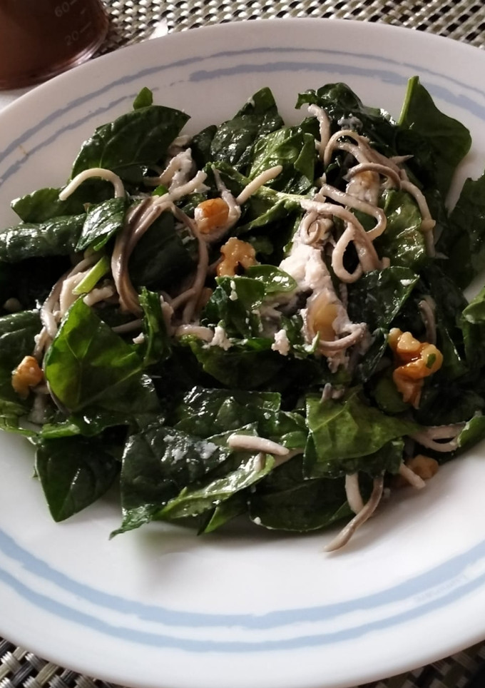 Una foto de Ensalada templada de espinacas, gulas al ajillo y rulo de cabra