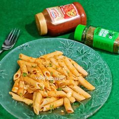 A picture of Penne in red sauce with herbs.