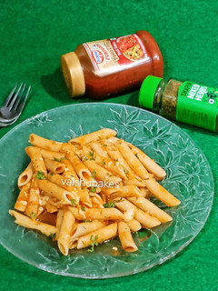 A picture of Penne in red sauce with herbs.